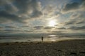 Silhouette of people enjoying and walking during peaceful moment of sunset at the beach Royalty Free Stock Photo