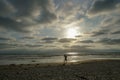 Silhouette of people enjoying and walking during peaceful moment of sunset at the beach Royalty Free Stock Photo