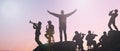 silhouette people of group musicians standing atop the mountain is a breathtaking sight with a beautiful sunset in Sky background