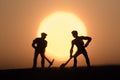 Silhouette people mining on sky sunset background. Royalty Free Stock Photo