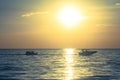 Silhouette of people playing banana boat on the sea with beautiful view of sunset light in the background at Chao Lao Beach. Royalty Free Stock Photo