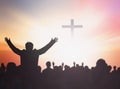 Silhouette people raising hands over blurred the cross on beautiful golden autumn sky sunset background Royalty Free Stock Photo