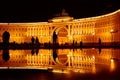 Silhouette of people with reflection in the puddle at Dvortsovaya square in Saint Petersburg at night