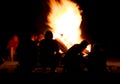 Silhouette of people sitting in front of a campfire in the night