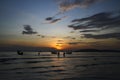 Silhouette of people or tourist walking to get up longtail boat to take trip with sea, sunset, blue sky and cloud background Royalty Free Stock Photo