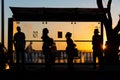 Silhouette of people waiting at the bus stop on the edge of Porto da Barra in Salvador, Brazil