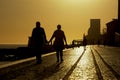 Silhouette of people a quay along river Tajus with Monument to the Discoveries in the background in Lisbon against sunset sky