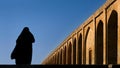 Silhouette of a Persian woman in national dress on the old Khaju Pol-e Khaju bridge in Isfahan. Iran. Ancient Persia.