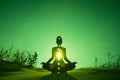 Silhouette of a person doing yoga with the root chakra symbol Royalty Free Stock Photo