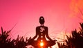 Silhouette of a person doing yoga with the root chakra symbol Royalty Free Stock Photo