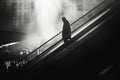 Silhouette of Person on Escalator in Misty City. Royalty Free Stock Photo