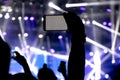 Silhouette of a person hand shooting the concert with his smart phone