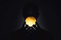 Silhouette of a person holding a glowing orb in darkness Royalty Free Stock Photo