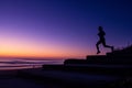 silhouette of person jogging on beach steps at dawn Royalty Free Stock Photo