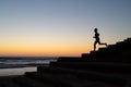 silhouette of person jogging on beach steps at dawn Royalty Free Stock Photo