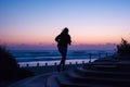 silhouette of person jogging on beach steps at dawn Royalty Free Stock Photo