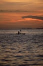 Silhouette of person kayaking at sea during sunset