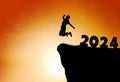 Silhouette of a person leaping from 2024 on the top of the mountain background Royalty Free Stock Photo