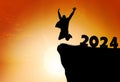 Silhouette of a person leaping from 2024 on the top of the mountain background Royalty Free Stock Photo