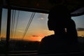 silhouette of a person looking out from a cable car at sunset Royalty Free Stock Photo