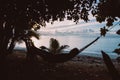 Silhouette of person lying down on hammock