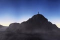 Silhouette of a person on the peak of a mountain on a starry blue background. 3d render