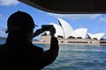 Silhouette of a person photographing Sydney Opera House in New S