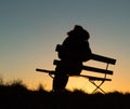 Silhouette of a person sitting on a bench in sunset Royalty Free Stock Photo