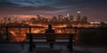 Silhouette of a person sitting on a park bench overlooking a city skyline at sunset. Royalty Free Stock Photo