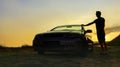 Silhouette person standing with convertible car enjoying a summer day