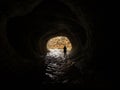 Silhouette of a person standing in dark black natural water tunnel at Broken River Cave Stream Reserve, New Zealand Royalty Free Stock Photo