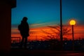 a silhouette of a person standing in front of a street light