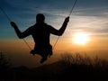 A silhouette of a person swinging towards the sun on the top of Mt. Lowe, Los Angeles, San Gabriel National Forest