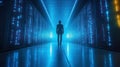A silhouette of a person walking through a high-tech server room illuminated by blue lights Royalty Free Stock Photo