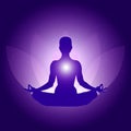 Silhouette of Person in yoga lotus asana on dark blue purple background with lotus flower and light Royalty Free Stock Photo