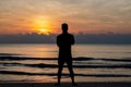 The silhouette photo of a man standing alone on the beach enjoy sunrise moment