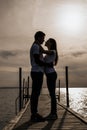 Silhouette photo of romantic couple enjoying sunset harbor view Royalty Free Stock Photo