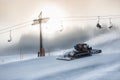 Silhouette photo of snow removal machine working on high ski slope Royalty Free Stock Photo