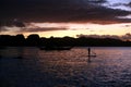 A silhouette photo of a young girl on a standing paddle. Active holidays, life on the beach. Philippines