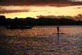 A silhouette photo of a young girl on a standing paddle. Active holidays, life on the beach. Philippines