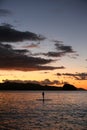 A silhouette photo of a young girl on a standing paddle. Active holidays, life on the beach. Philippines