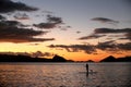 A silhouette photo of a young girl on a standing paddle. Active holidays, life on the beach. Philippines