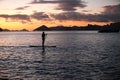 A silhouette photo of a young girl on a standing paddle. Active holidays, life on the beach. Philippines