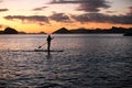 A silhouette photo of a young girl on a standing paddle. Active holidays, life on the beach. Philippines