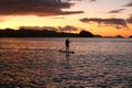 A silhouette photo of a young girl on a standing paddle. Active holidays, life on the beach. Philippines