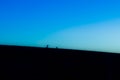 Silhouette of a photographer capturing a model on a hill during the sunset