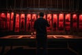 Silhouette of a photographer developing photos in a dark room. Man hanging printed photos in red lighted room. Old style