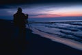 Silhouette of a photographer at dusk on a deserted beach Royalty Free Stock Photo