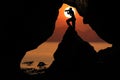 Silhouette photographer in front of the cave near the sea with r Royalty Free Stock Photo