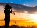 Silhouette photographer in grass field